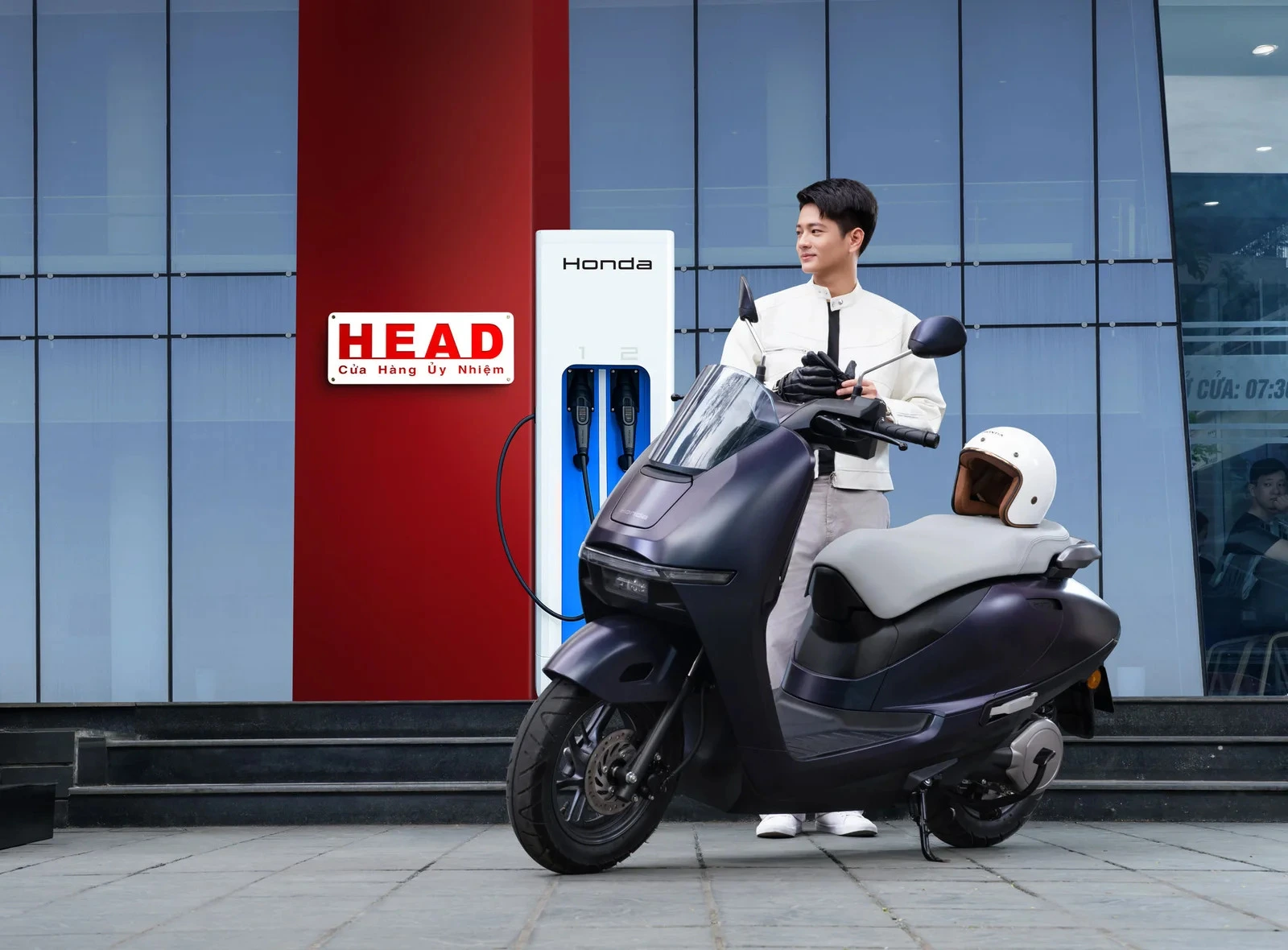 Trạm sạc Honda hai đầu sạc đặt trước cửa hàng HEAD, bên cạnh một chiếc xe máy điện Honda